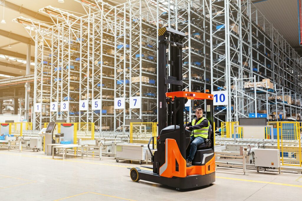 Employee working on forklift in modern automatic warehouse. Industrial Mockup with copy space